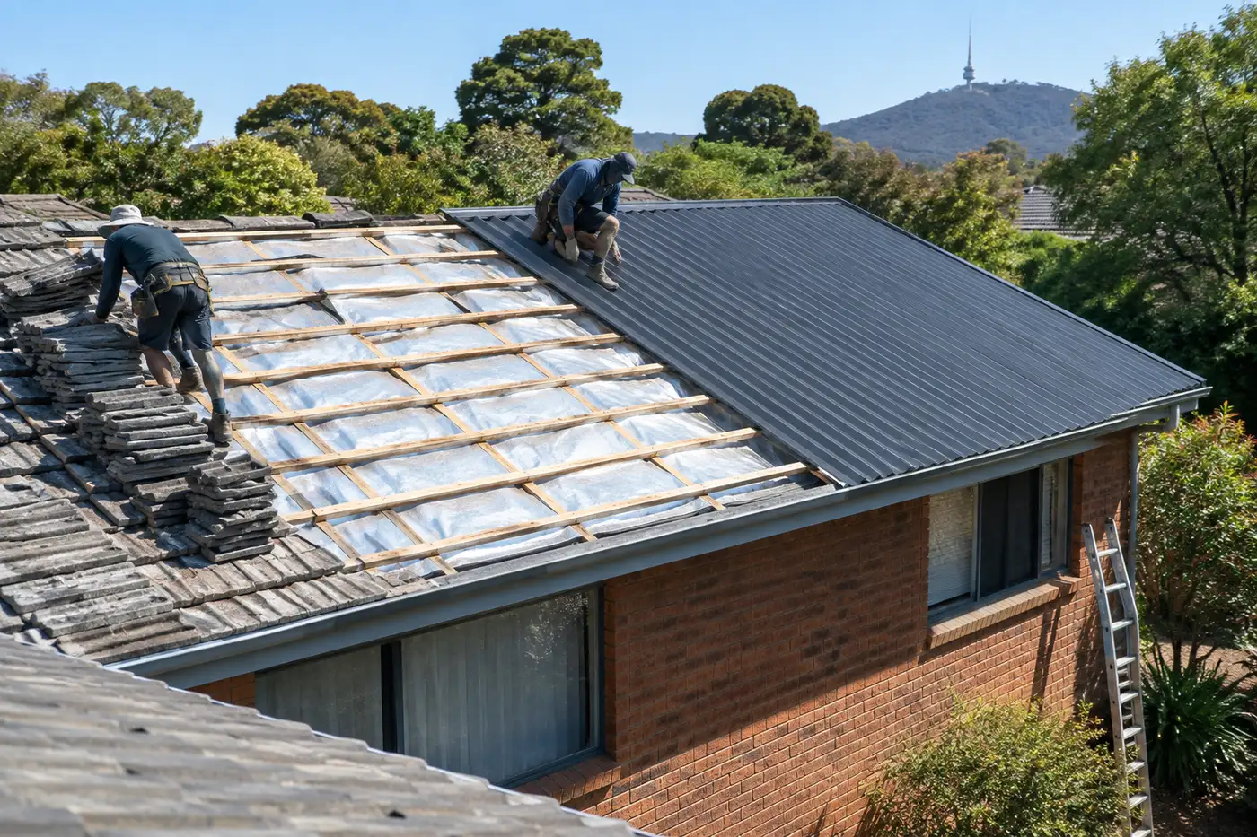 A Canberra brick home halfway through a re-roof, old concrete tiles stripped back to timber battens and sarking on one side, new charcoal Colorbond sheets on the other