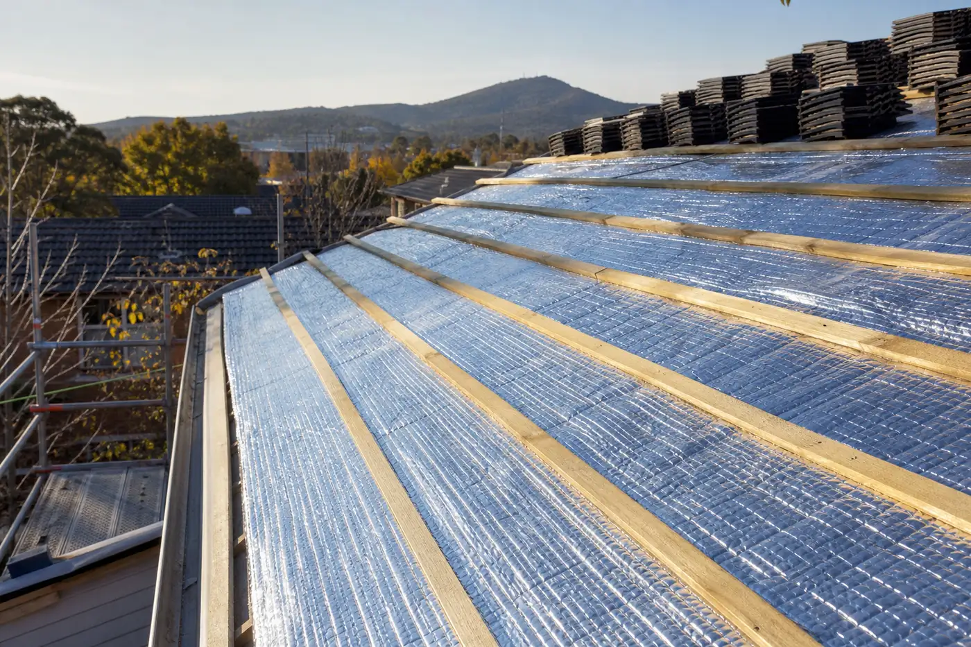 Reflective silver foil sarking laid over roof battens during a Canberra re-roof