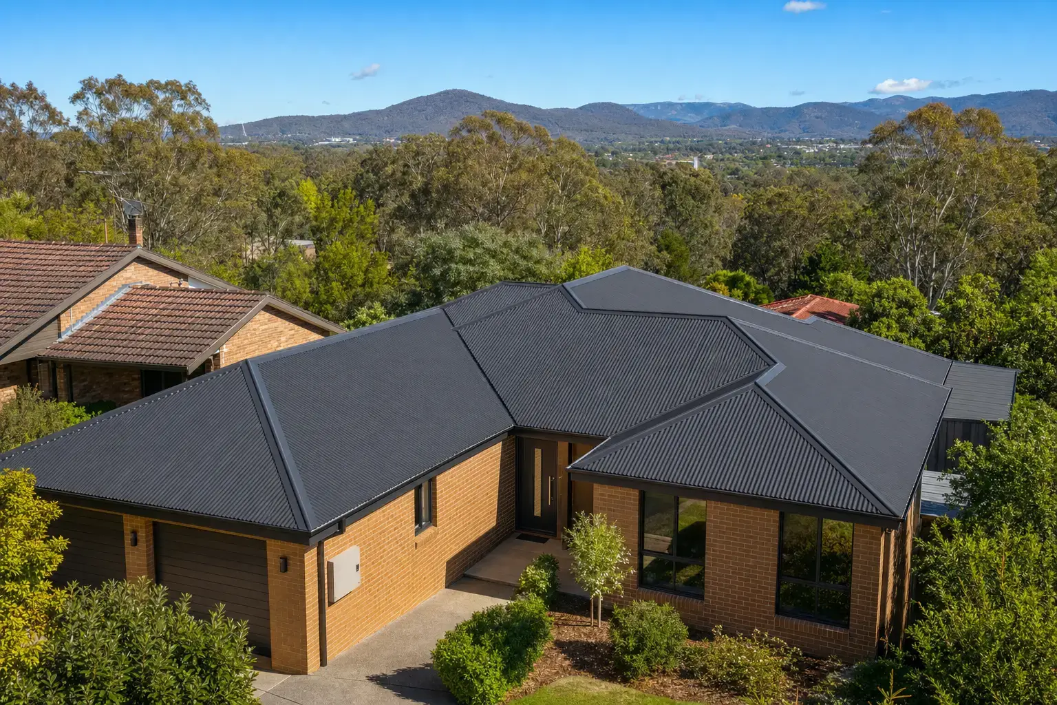 New charcoal Colorbond roof on a Canberra home, the Brindabellas behind โ Roof Restoration Canberra