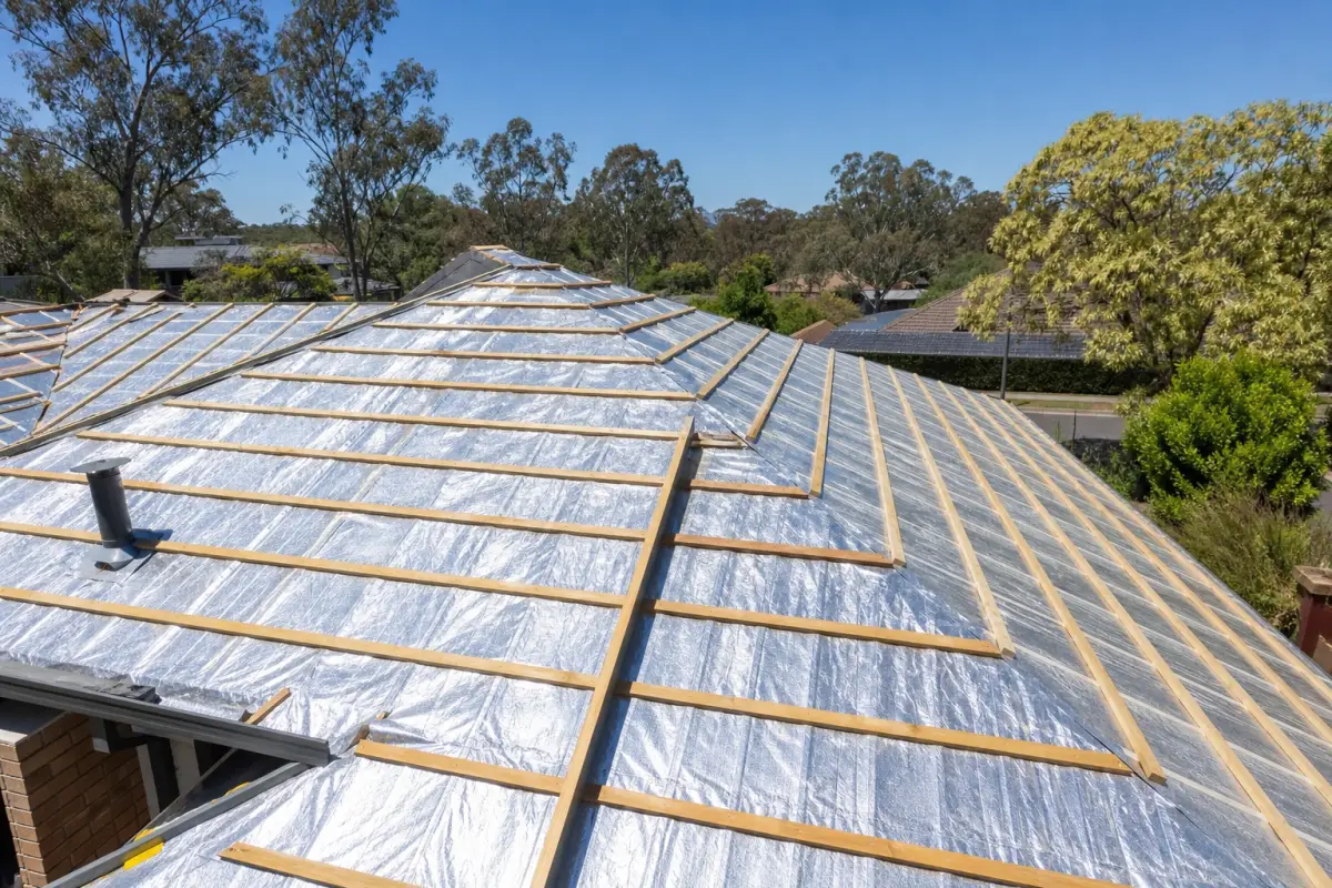 Reflective foil sarking laid over roof battens during a Canberra re-roof